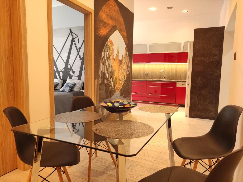 a dining room with a glass table and chairs at K2012 Kalina Grand-Tourist Apartments in Gdańsk