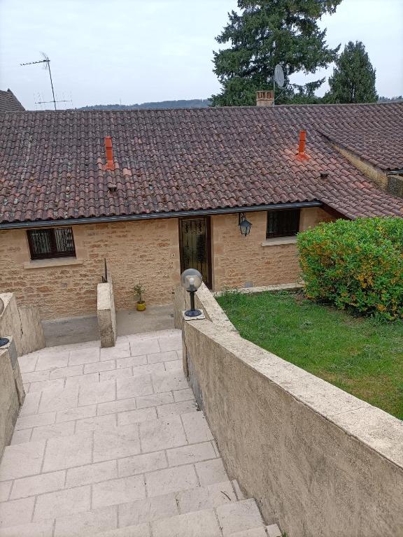 une maison avec un mur en pierre devant une cour dans l'établissement Gîte T3 Sarlat d'oie, à Sarlat-la-Canéda