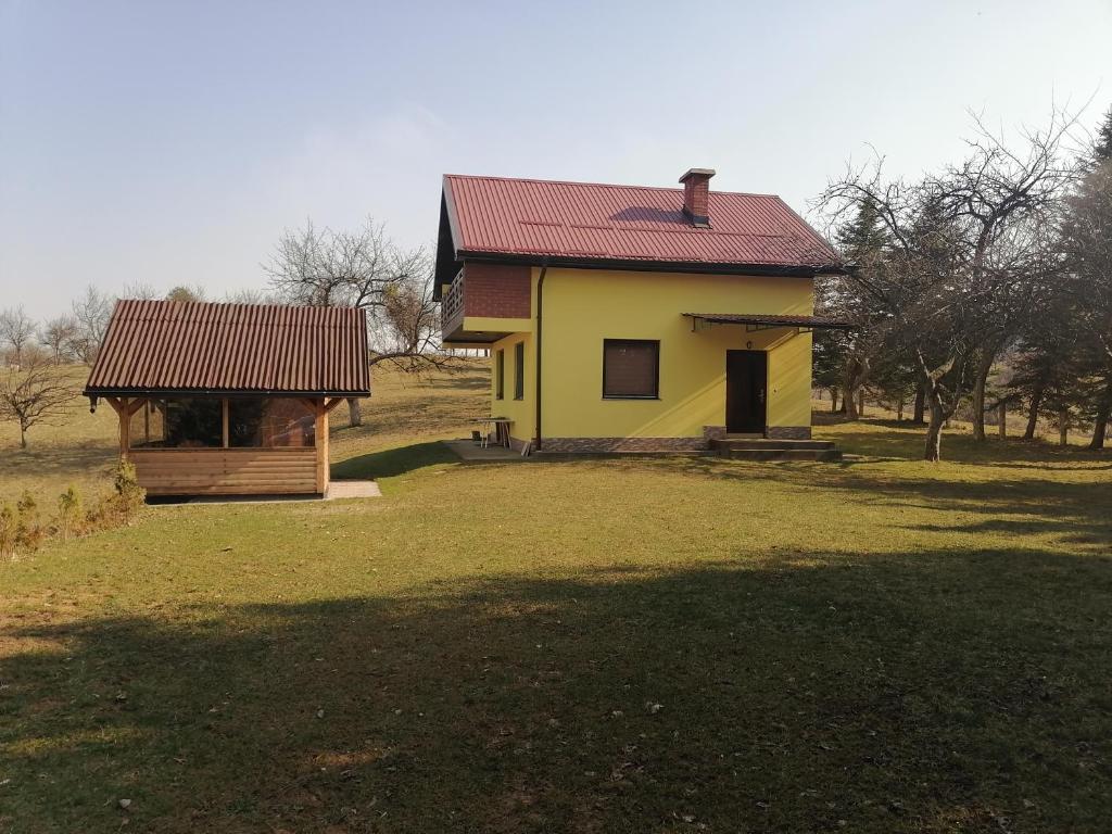 a yellow house with a red roof and a gazebo at Zuta Kuca Sunca in Visoko