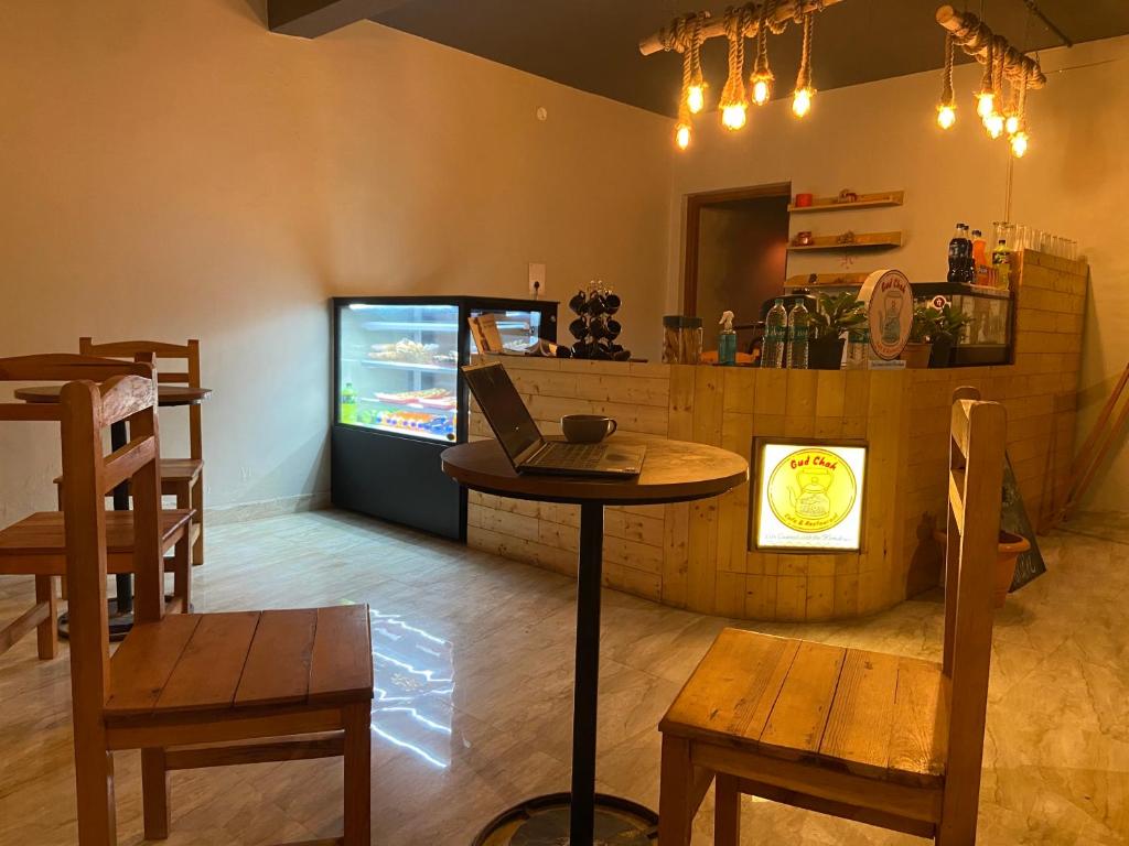 un bar con ordenador portátil sobre una mesa y TV en Gud Chah Cafe & Homestay, en Chaukori