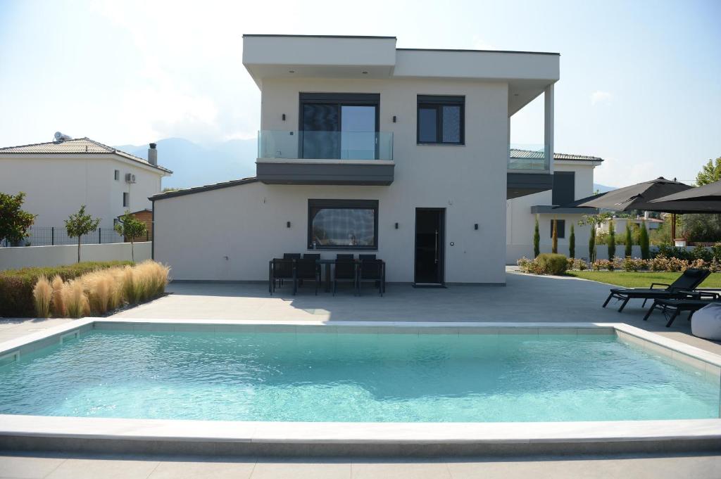 uma villa com piscina em frente a uma casa em Luxury Villa Plaka Litochoro em Plaka Litochorou