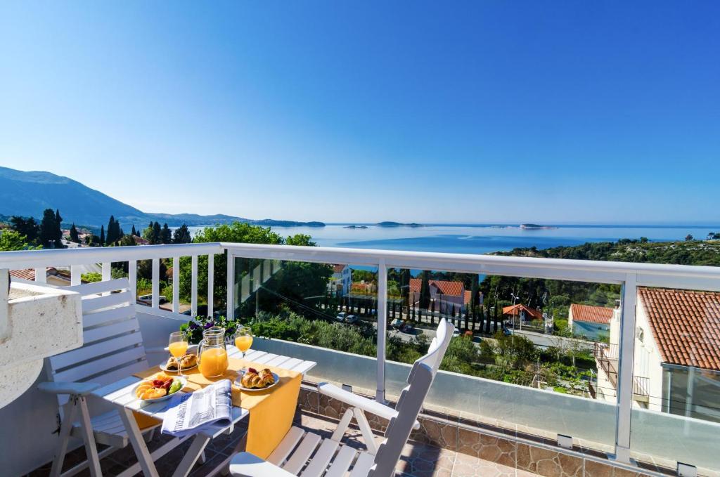 a balcony with a table and chairs and the ocean at Apartments Knego in Mlini