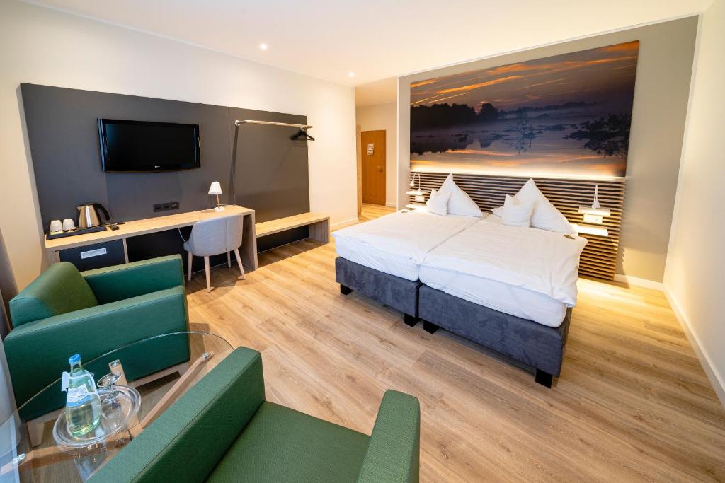 een hotelkamer met een bed, een bureau en een bank bij Hotel Restaurant Kloppendiek in Vreden