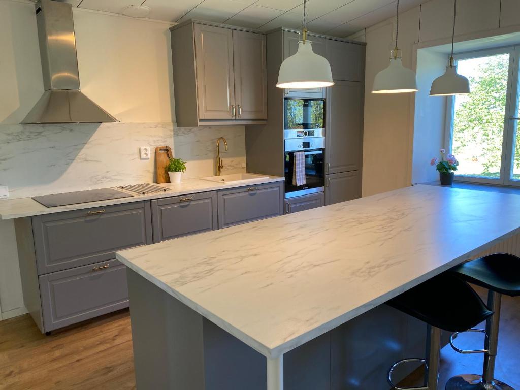 a kitchen with a large white counter top in a room at Hangvar Skola Geografisalen in Lärbro