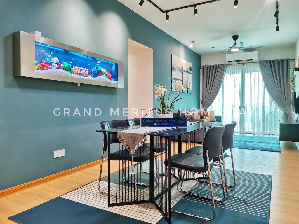 北賴的住宿－Grand Meritus Homestay @Penang，用餐室配有餐桌和墙上的电视