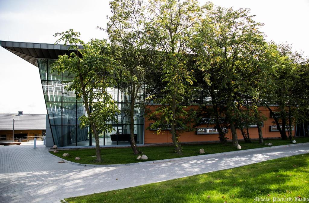 un bâtiment avec des arbres devant lui dans l'établissement Hipodrom Sopot, à Sopot