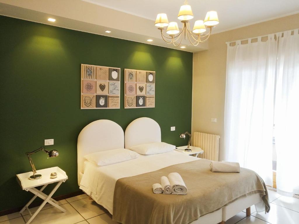 a bedroom with a large bed with a green wall at Villa Anna in Reggio di Calabria