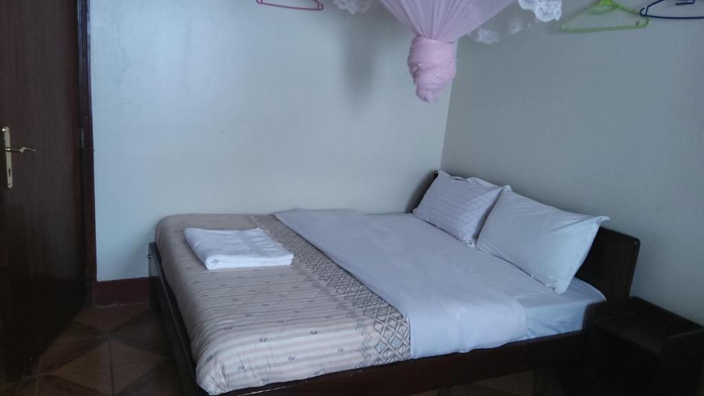 Mbale的住宿－Lucia Villas Mbale，一张带白色床单和枕头的床