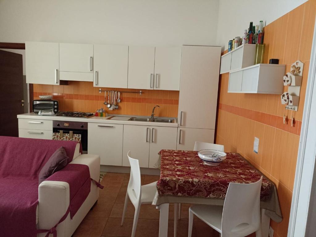 una cucina con tavolo e sedie e una cucina con divano di Bella Mbriana casa vacanze a Vietri