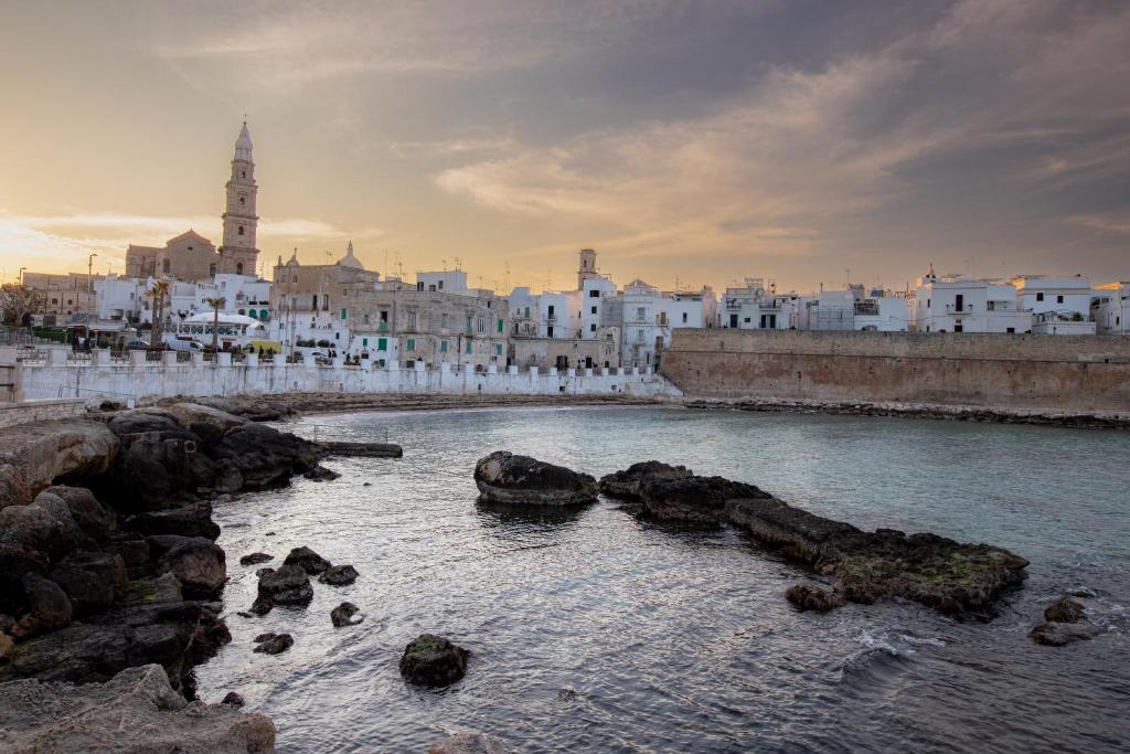 a river with rocks in front of a city at Borgo Cozzana Mare in Monopoli