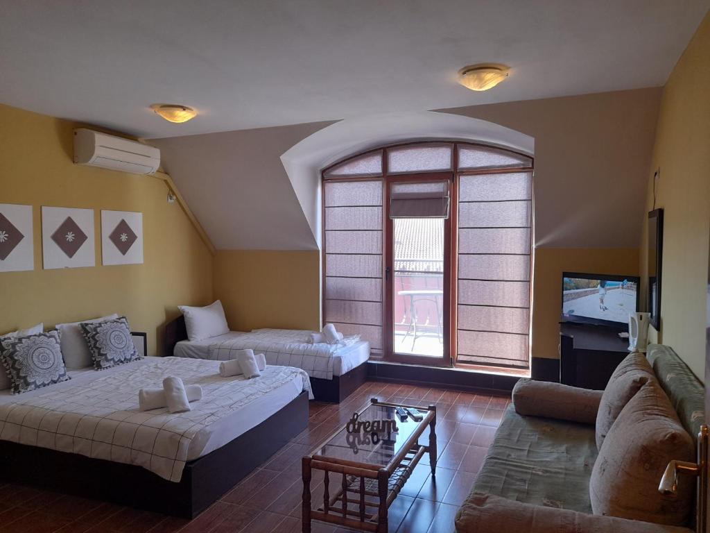 a living room with two beds and a couch at FOTIADIS BOUTIQUE RООМS and STUDIOS in Veliko Tŭrnovo