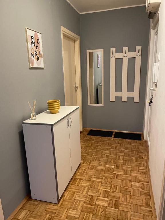 een kamer met een witte kast en een houten vloer bij Apartman Prima Sombor in Sombor