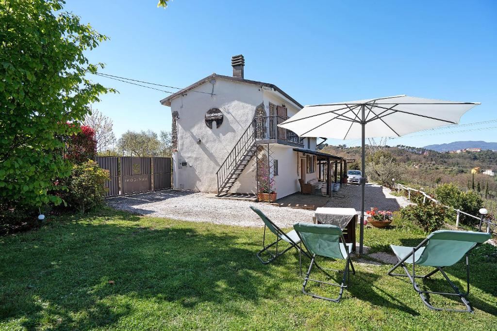 una casa con dos sillas y una sombrilla en el patio en Rosadimaggio Camelia, en Arcola