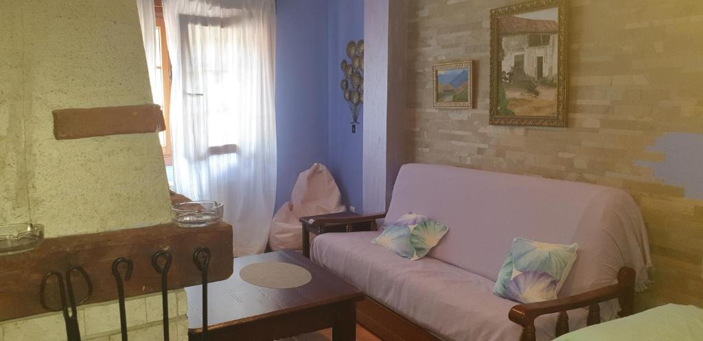 ein Wohnzimmer mit einem Sofa und einem Tisch in der Unterkunft Apartamentos Andrea in Belmonte de Miranda