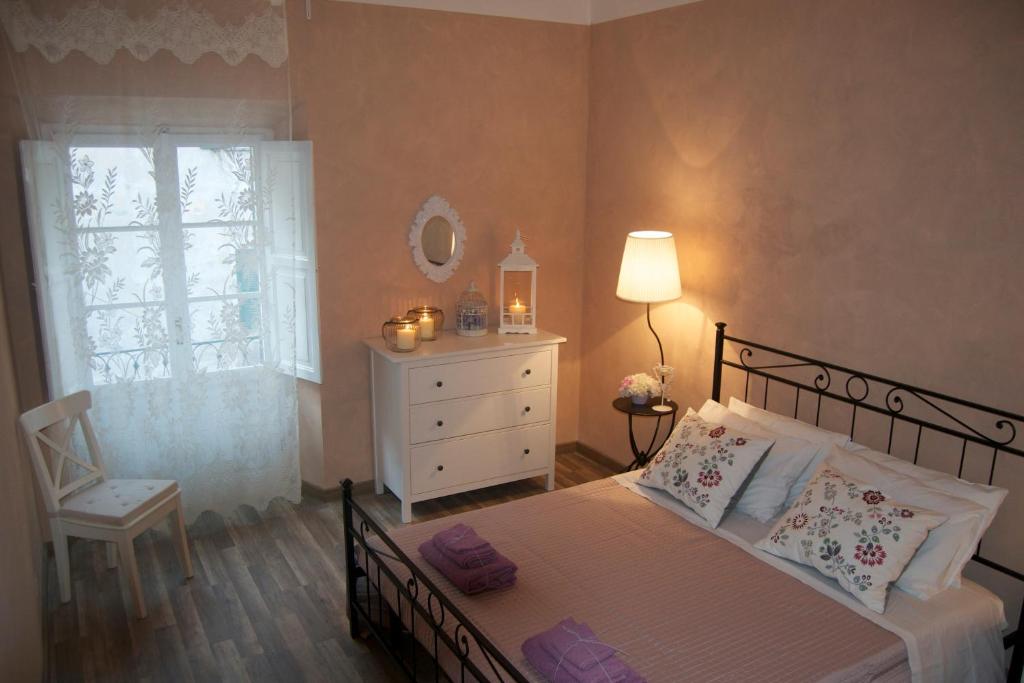 sypialnia z łóżkiem, komodą i oknem w obiekcie House Colosseo w Rzymie
