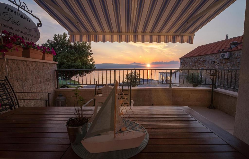 a balcony with a table and a view of the sunset at Dida moj in Senj
