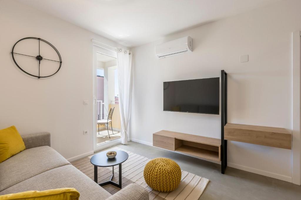 Televízia a/alebo spoločenská miestnosť v ubytovaní PORTO SERENO apartments
