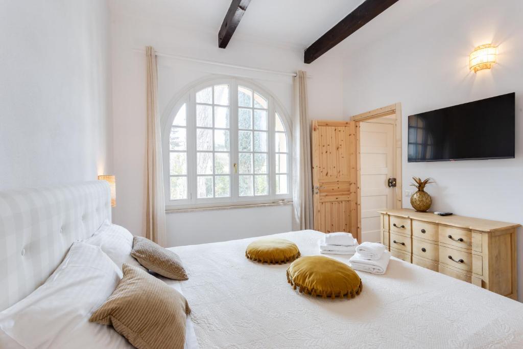 a bedroom with a white bed with two pillows on it at Maison d'Orange - La Pinede in Saint-Tropez