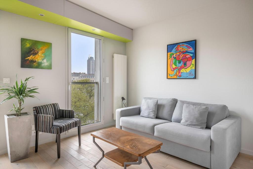 un soggiorno con divano e sedia di En plein coeur de ville, bel appartement pour cinq personnes a Nantes