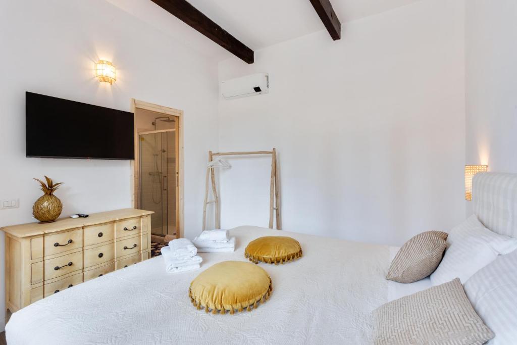 a bedroom with a white bed with pillows on it at Maison d'Orange - La Pinede in Saint-Tropez