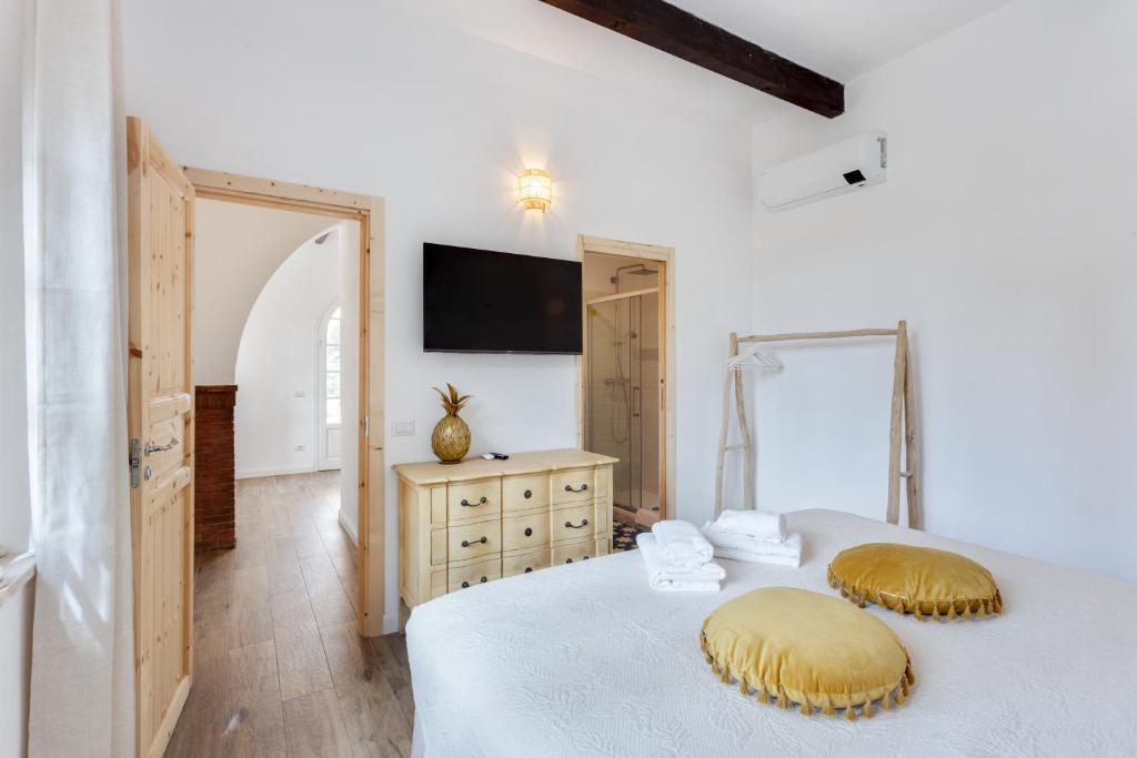 a bedroom with two beds and a tv on the wall at Maison d'Orange - La Pinede in Saint-Tropez