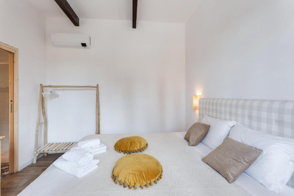 a white bed with two pillows on top of it at Maison d'Orange - La Pinede in Saint-Tropez