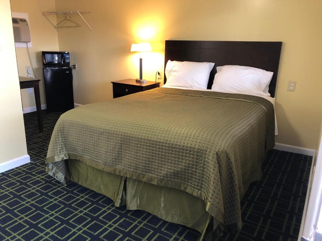 a hotel room with a bed and a refrigerator at Rosewood Motel in East Wareham