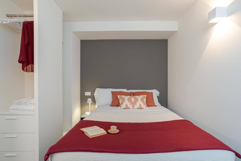 a small bedroom with a bed with a red blanket at Suite Brunate - by MyHomeInComo in Como