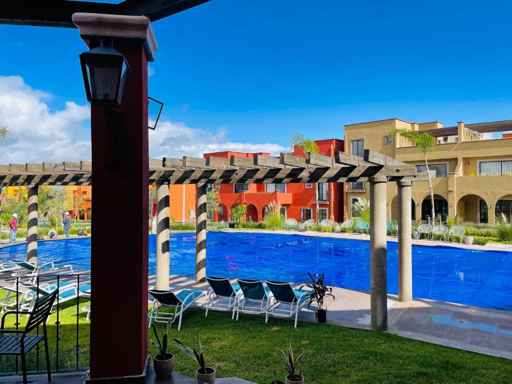 a swimming pool with chairs under a pergola at "San Miguelito" El oasis urbano que necesitas para descansar! pool, gym, tenis in San Miguel de Allende