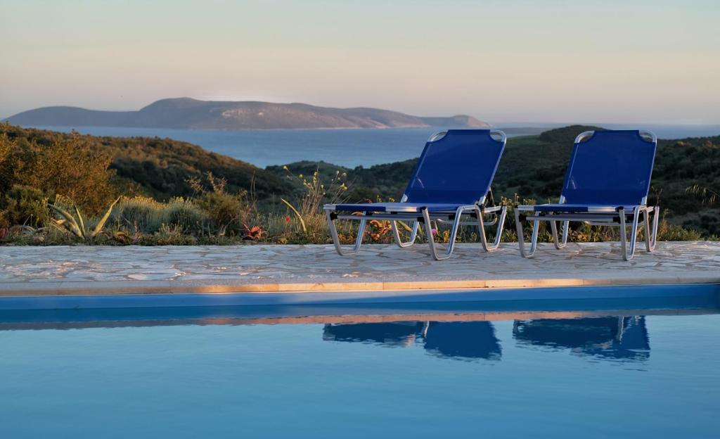 two blue chairs sitting next to a swimming pool at Villa Valleyview Methoni in Methoni