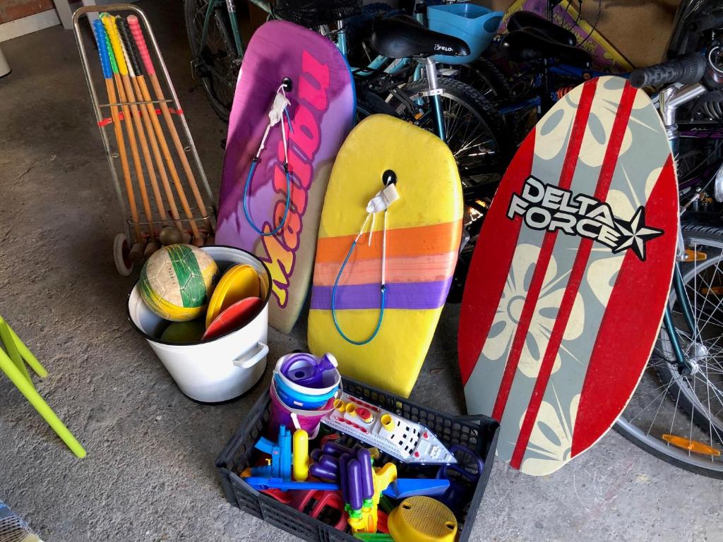 a group of surfboards and a basket of toys at La plage au bout du jardin &#47; Sword Beach cottage in Hermanville-sur-Mer
