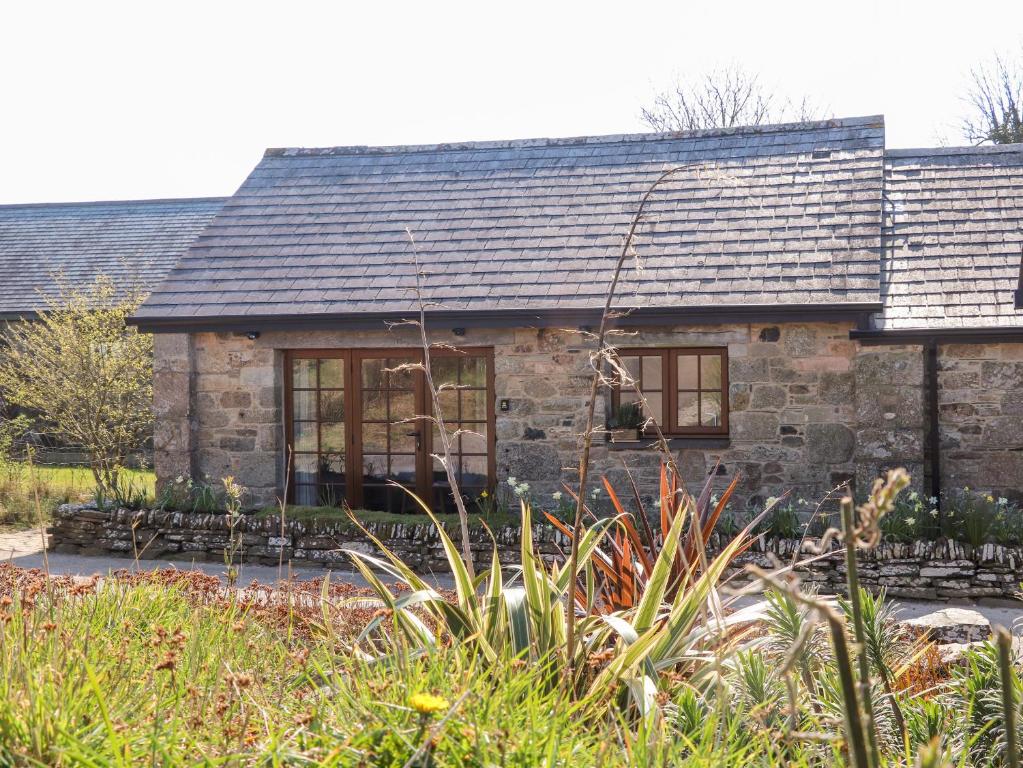 a stone house with a garden in front of it at Rosewarrick Cottage in Bodmin