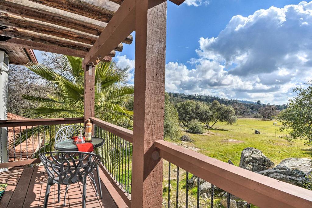 a balcony with a table and a view of a field at Romantic Treetop Studio 30 Mi to Yosemite! in Coarsegold