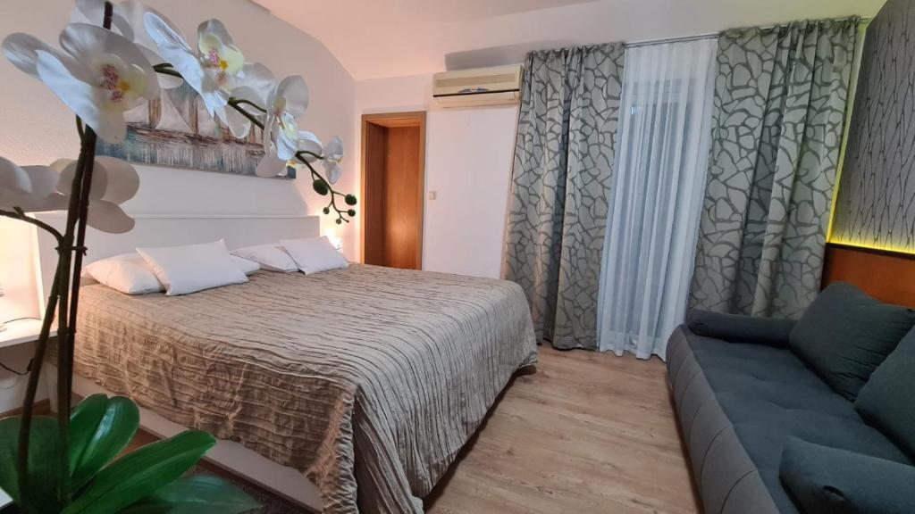 a bedroom with a bed and a couch at SOBE/ROOMS RIVA in Zadar