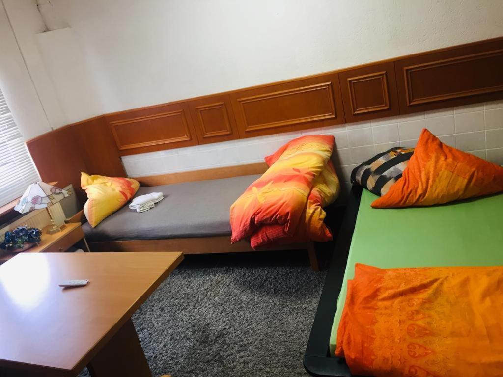 a room with two beds with colorful pillows at Neo Event Hall room Neo1 in Staufenberg