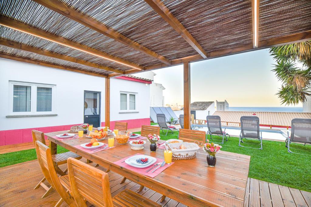 a wooden table and chairs on a deck with a patio at Elevator's Beach House in Albufeira