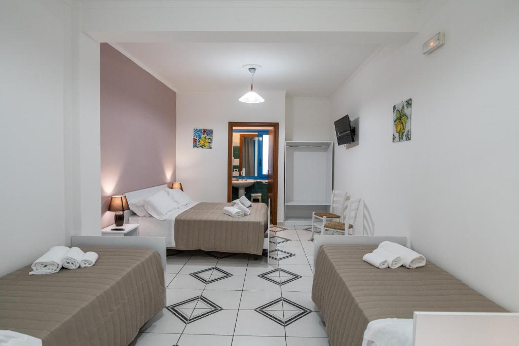 a bedroom with two beds and a living room at Ada Hotel & Apartments in Giardini Naxos