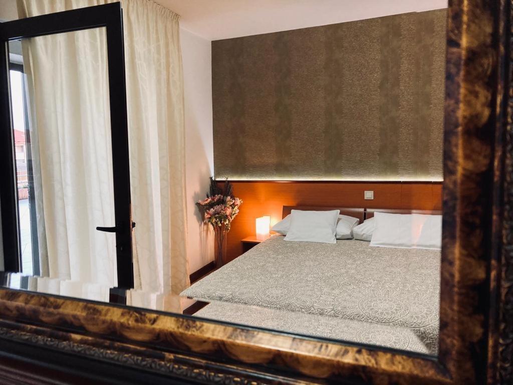 a reflection of a bedroom with a bed and a mirror at SOBE/ROOMS RIVA in Zadar