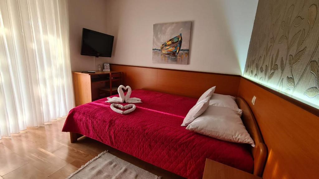 a bedroom with a red bed with a stuffed animal on it at SOBE/ROOMS RIVA in Zadar