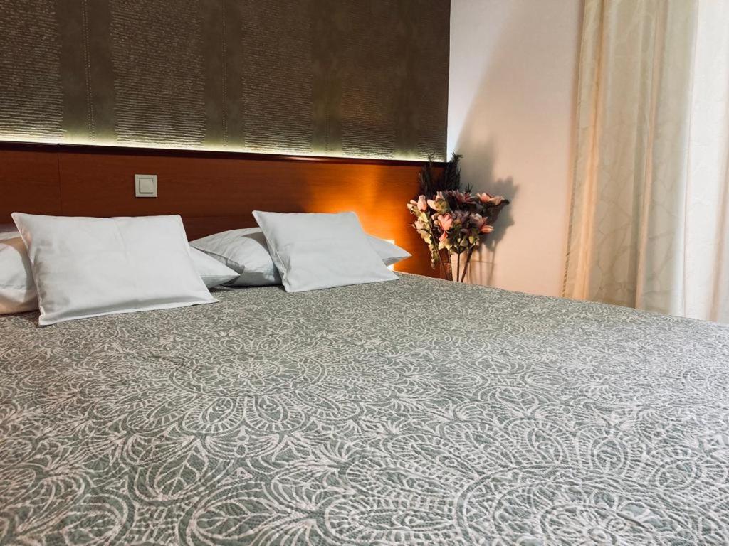 a bed with two pillows and a headboard with at SOBE/ROOMS RIVA in Zadar