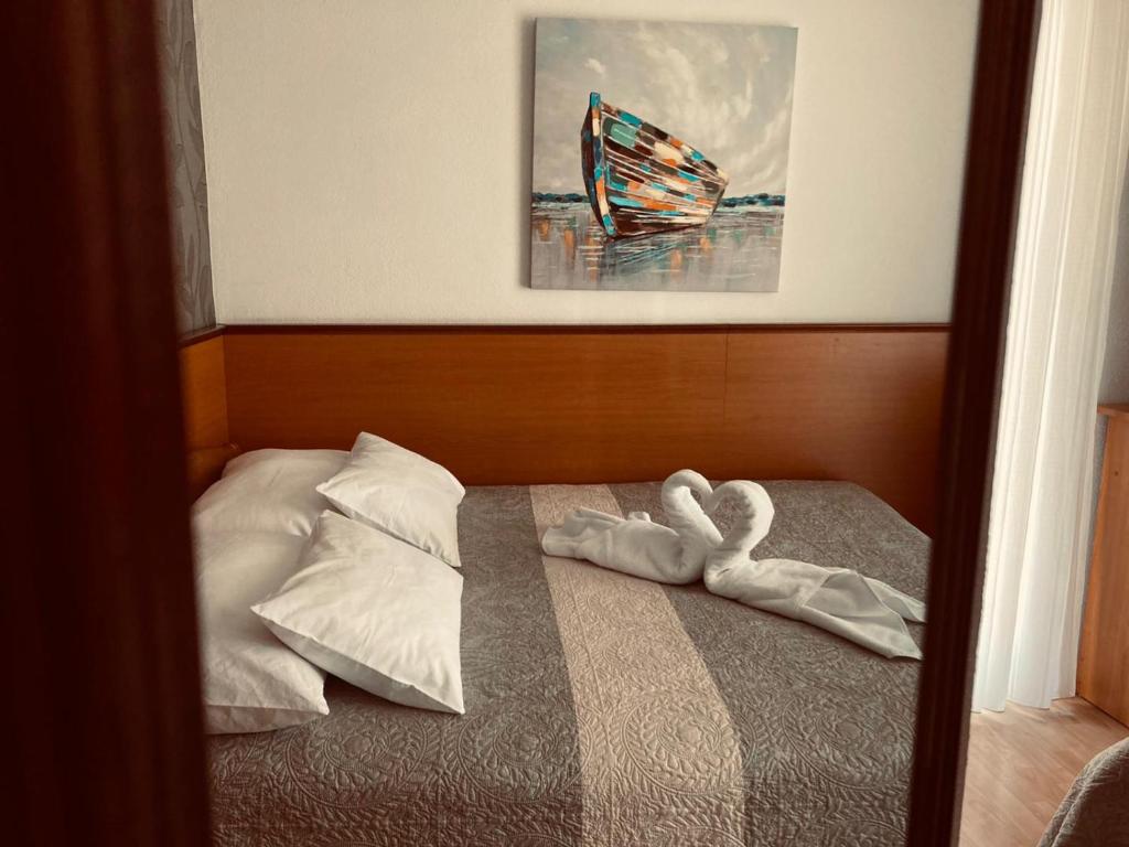 a bedroom with a bed with two swans on it at SOBE/ROOMS RIVA in Zadar