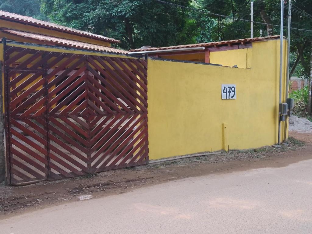 un bâtiment jaune avec une porte en bois avec le numéro dans l'établissement Casa de temporada Lindas Cachoeiras 10, à Parati