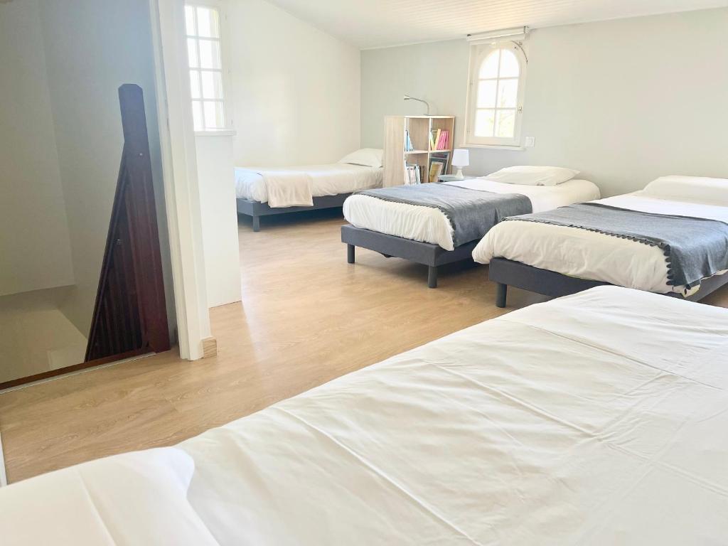 Zimmer mit 3 Betten und einem Spiegel in der Unterkunft Le Gîte du Petit Plessis in Saint-Viaud