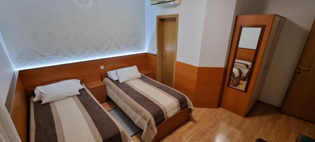 a small room with two beds and a mirror at SOBE/ROOMS RIVA in Zadar