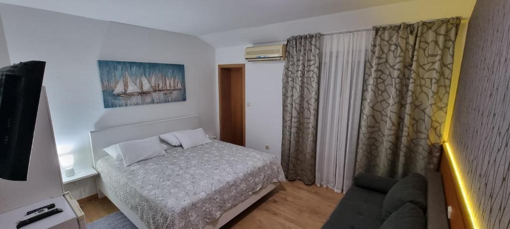 a small bedroom with a bed and a couch at SOBE/ROOMS RIVA in Zadar