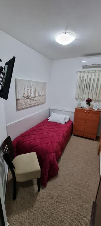 a bedroom with a red bed in a room at SOBE/ROOMS RIVA in Zadar