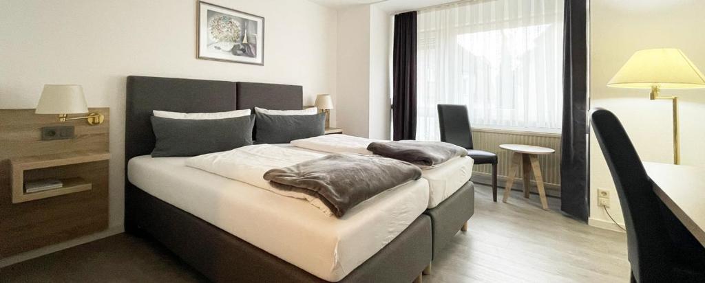 シュトゥットガルトにあるホテル フレイホフのベッドルーム1室(大型ベッド1台付)