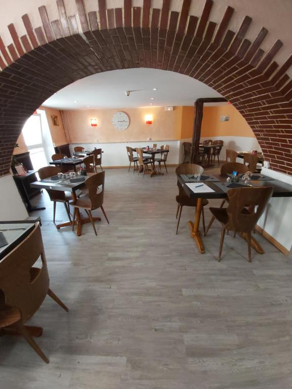 un ristorante con tavoli e sedie e un muro di mattoni di La chaumiere a Seyne