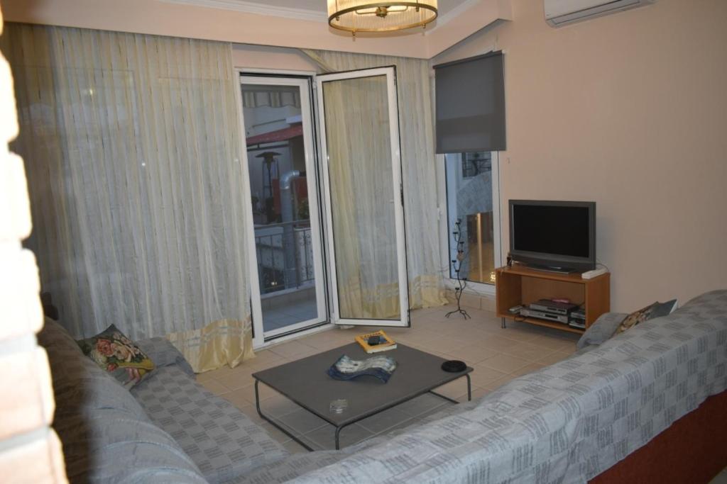 salon z kanapą i telewizorem w obiekcie Central Luxury Apartment next to the Beach w mieście Ofrynio