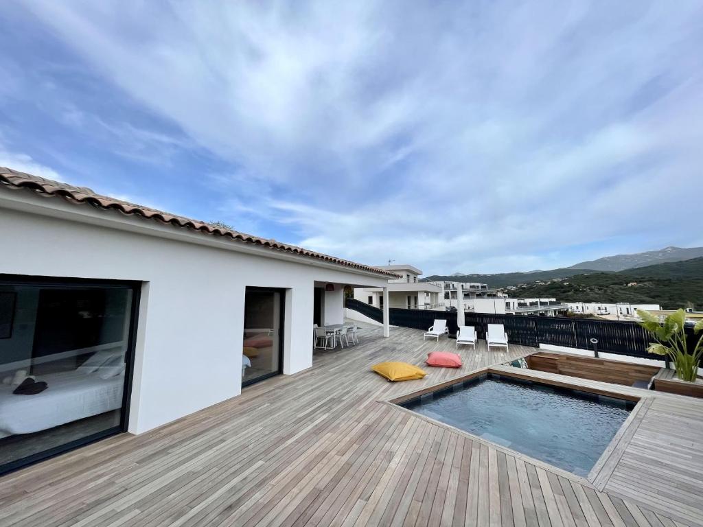 una terraza con piscina y una casa en Villa U Pastore, en Porticcio